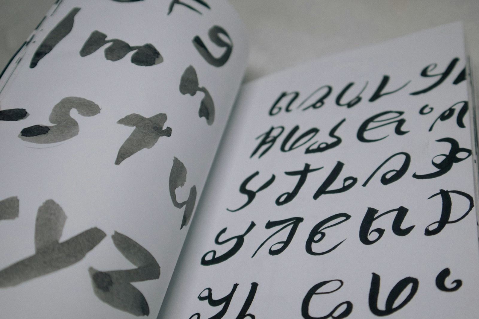 A close-up of an open book covered in dense handwriting, in low warm light